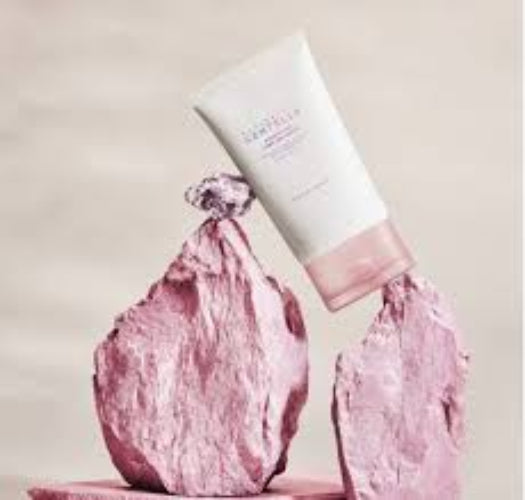 SKIN1004 Centella Poremizing Light Gel Cream tube elegantly balanced on pink textured rocks against a soft beige background.