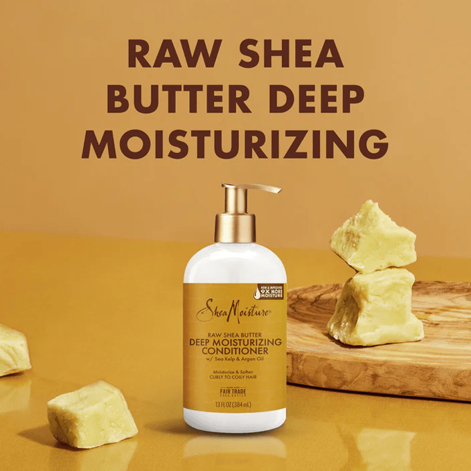 SheaMoisture Raw Shea Butter conditioner bottle displayed alongside chunks of natural shea butter on a wooden tray